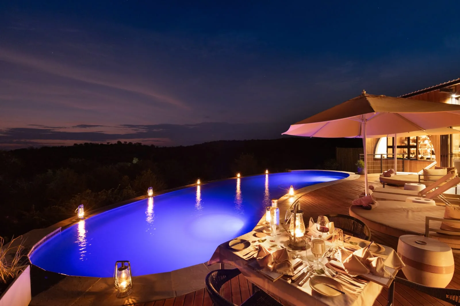 Poolside dinner setting under the night sky